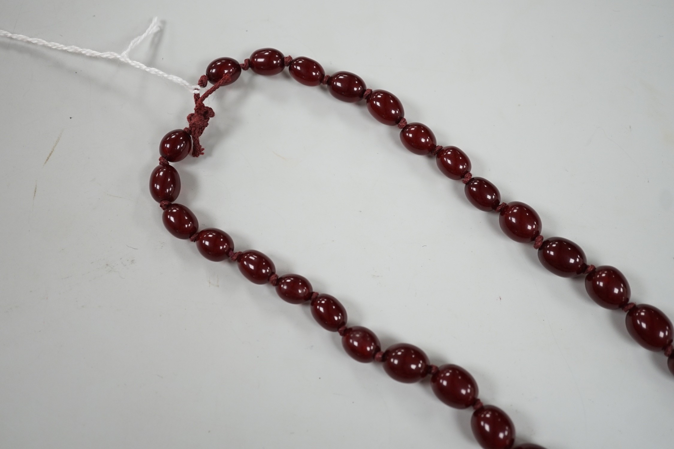 A single strand graduated simulated cherry amber necklace, 82cm, gross weight 83 grams.